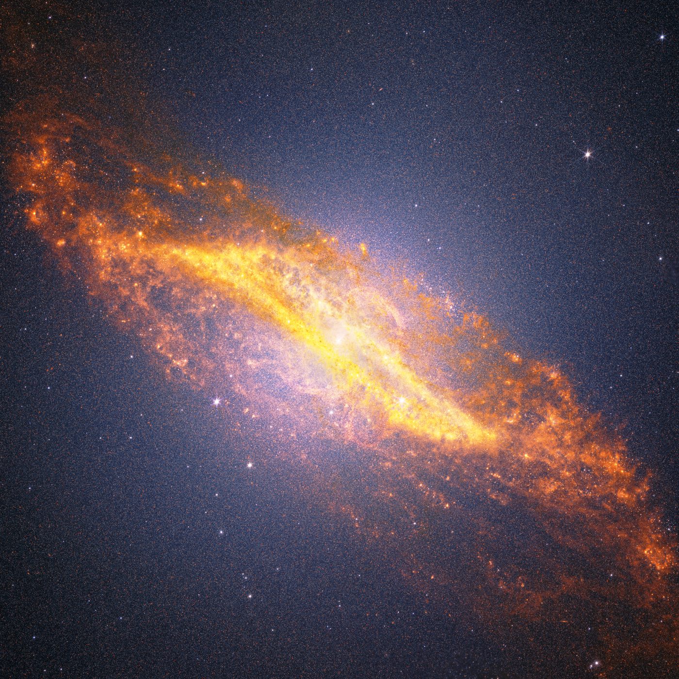 Centaurus A galaxy captured by Webb — a diagonal field of orange, blue and white stars with a golden parallelogram dust band across the center and an S-shaped structure above the core