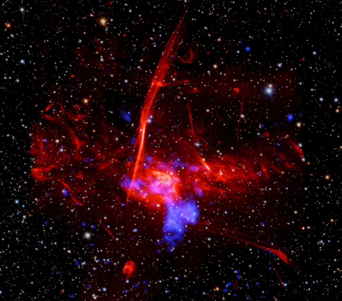Full composite of the Milky Way's galactic center: Chandra X-ray data in blue, XMM-Newton in cyan, MeerKAT radio in red, Pan-STARRS optical in background stars. The bright blue X-ray blob near the center is the possible supernova remnant.