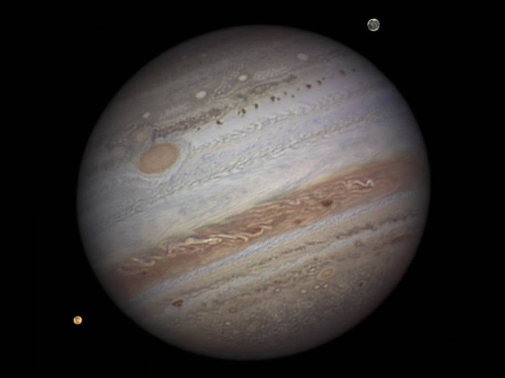 Jupiter photographed from a ground-based telescope — its cloud bands and Galilean moons visible
