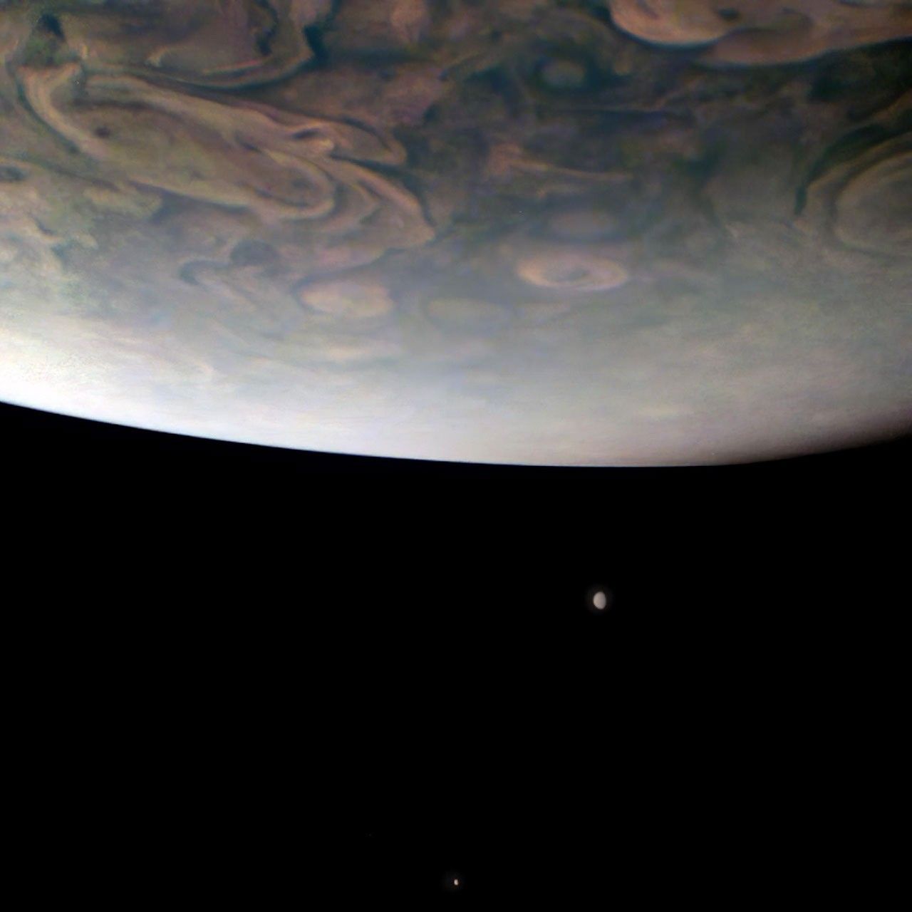 Jupiter with two of its Galilean moons — volcanic Io (left) and icy Europa (right) — photographed by NASA's Juno spacecraft's JunoCam during a close flyby