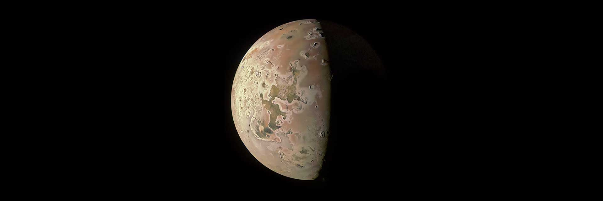 Jupiter's moon Io — a garish yellow-orange volcanic world photographed by NASA's Galileo spacecraft, showing active volcanic plumes and sulfur-rich surface