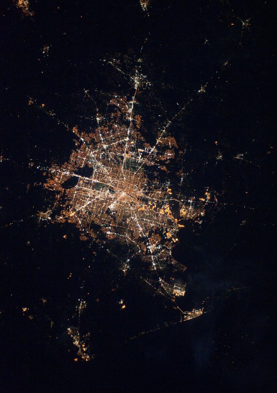 Houston at night photographed from the International Space Station, the light dome spreading across the flat coastal plain