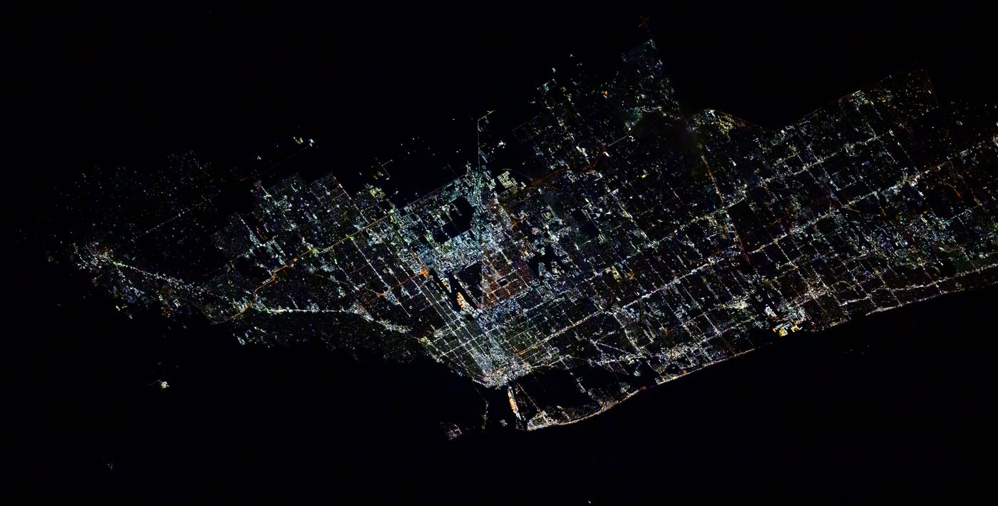 Miami and its suburbs at night from the International Space Station, a grid of white and orange street lights ending abruptly at the black Atlantic shoreline