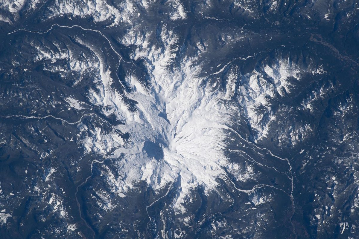 Snow-covered Mount Rainier and its radiating glaciers, photographed from the International Space Station