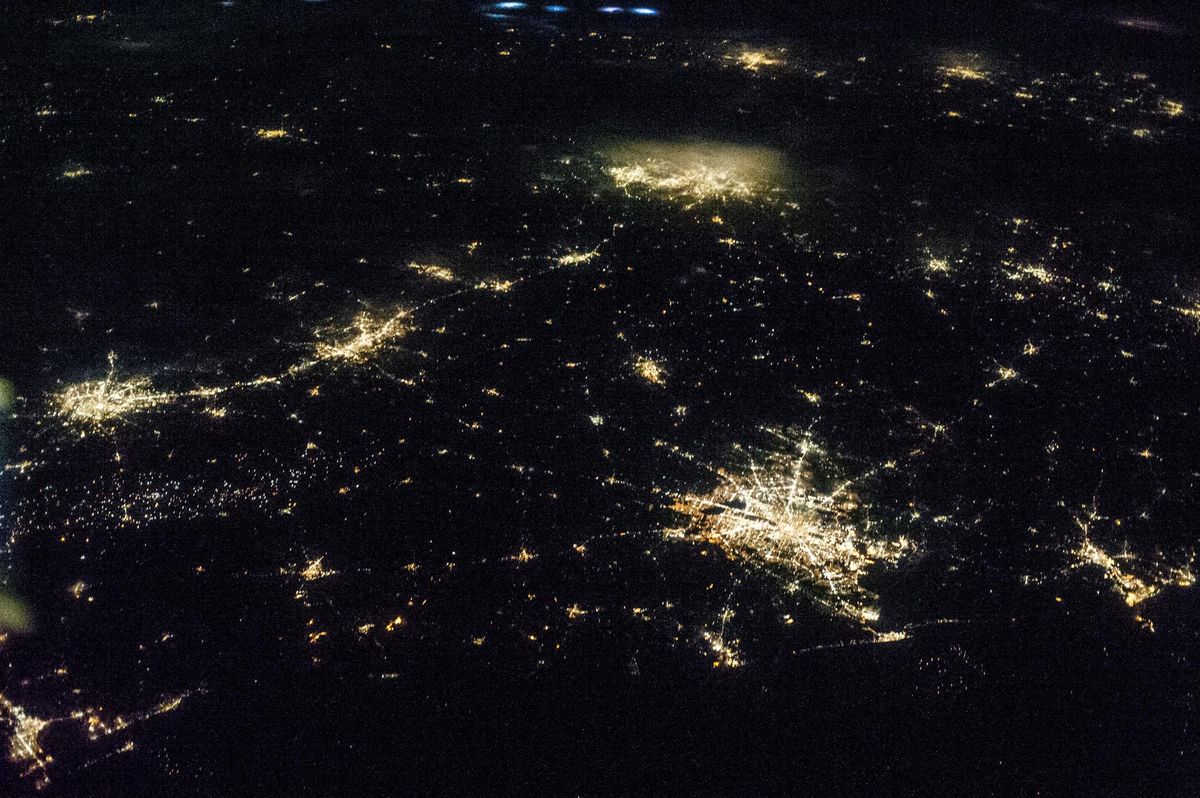 Oblique night view of Texas from the International Space Station showing the four largest metro areas as islands of light separated by dark country