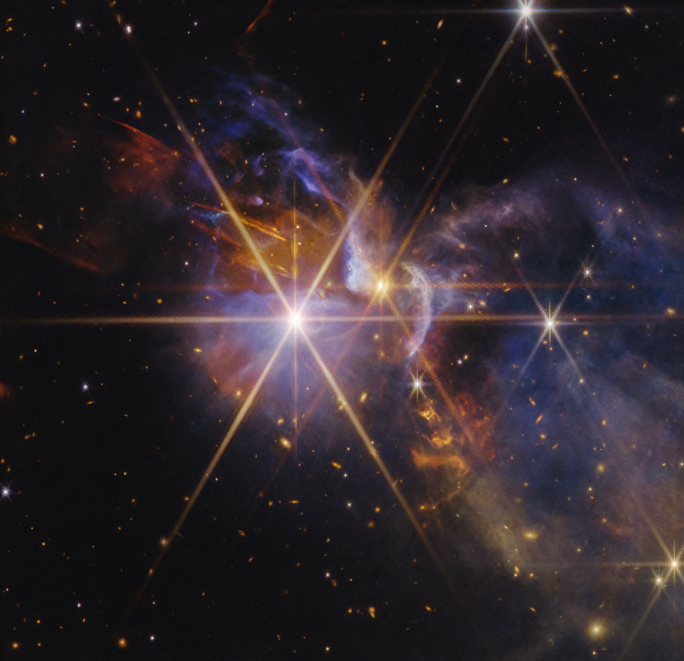 FS Tau star-forming region captured by Webb — clouds of blue and purple gas with bright protostars and countless distant galaxies