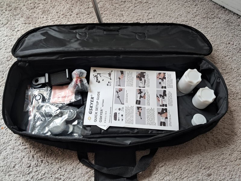 Gskyer 70mm accessory kit unpacked from the carry case — phone adapter, wireless remote, lens caps, and setup guide