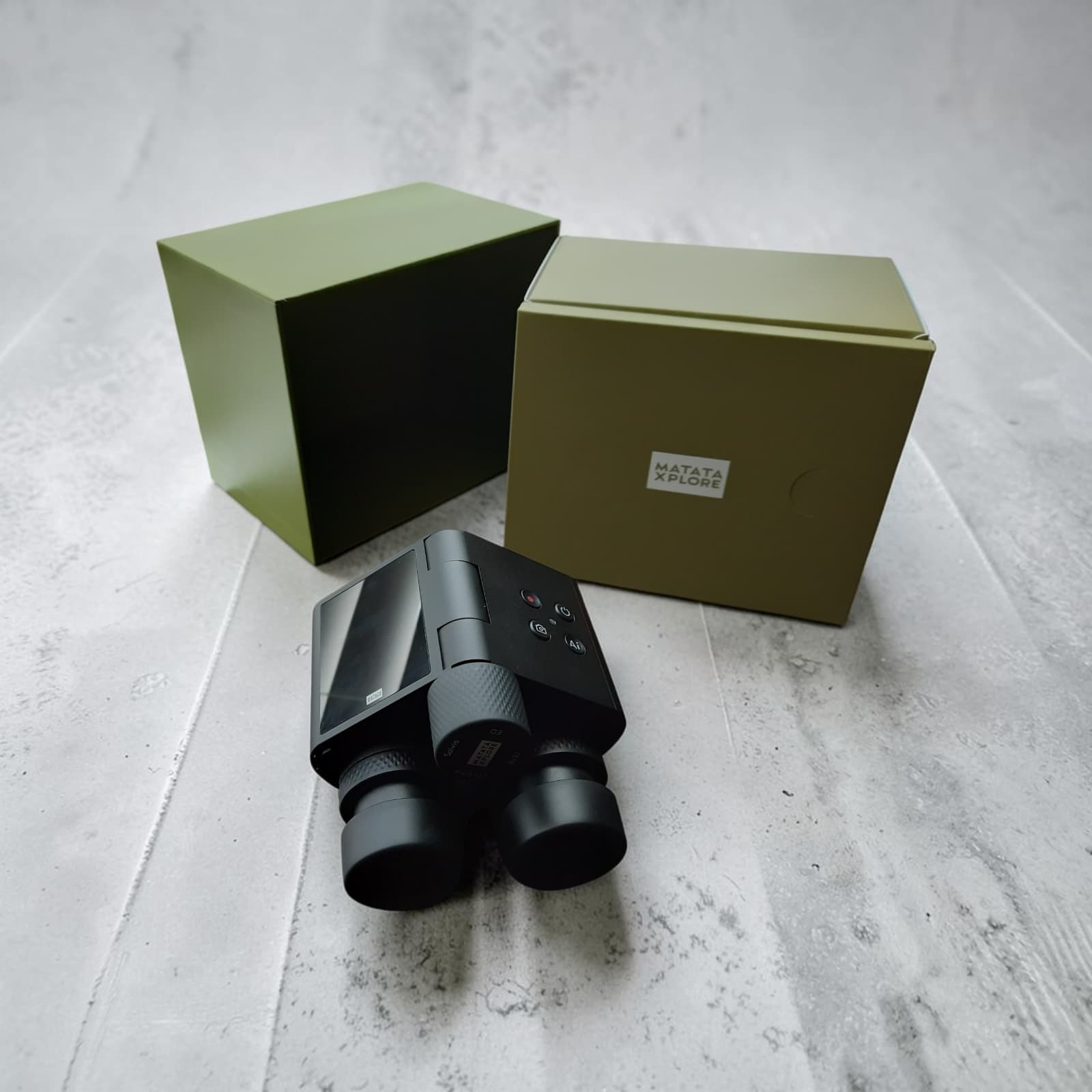 Solvia 8×32 AI Binoculars sitting in front of its open inner and outer packaging boxes on a concrete surface
