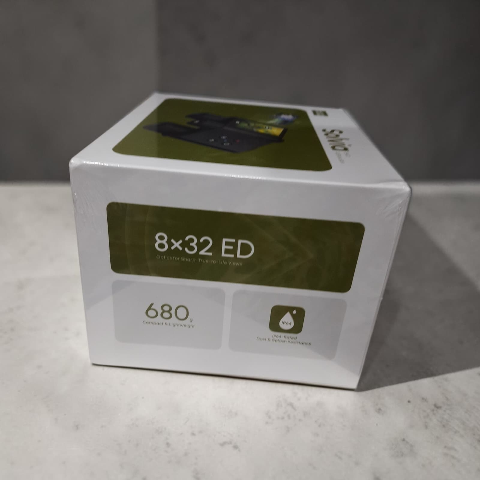 Sealed retail box for the Solvia 8×32 ED AI Binoculars, showing the 680g weight and IP64 dust/splash resistance rating printed on the packaging
