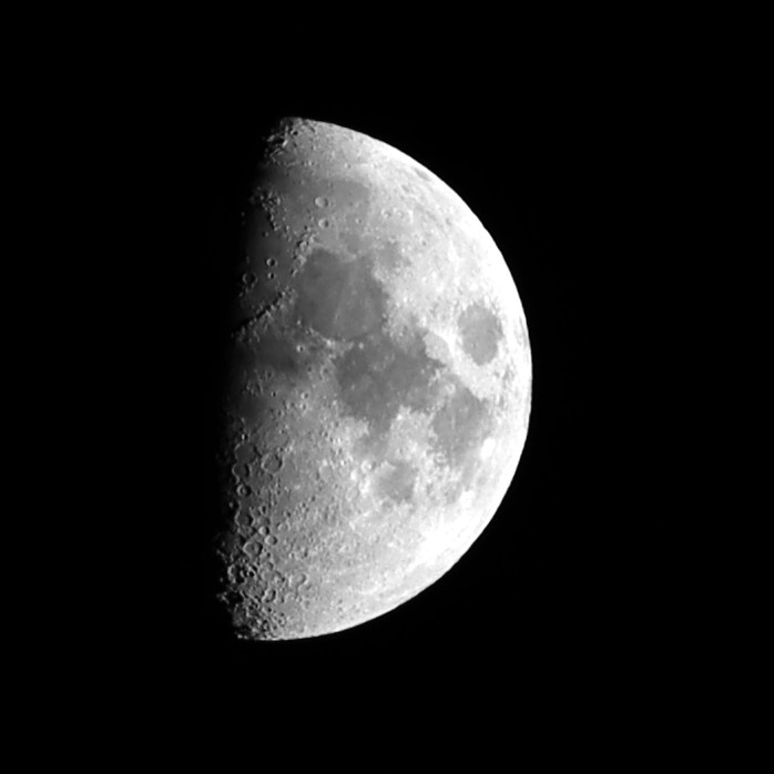 First-quarter Moon imaged with the SVBONY SV545 Petzval astrograph and a Canon EOS R100 — right half illuminated, terminator crater detail visible